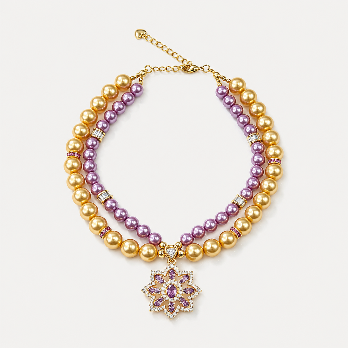 Double-strand purple and champagne pearl-effect pet necklace with a purple floral pendant on a white surface.