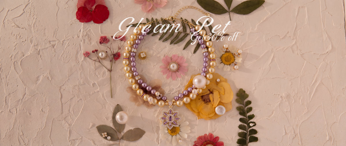 Gleam Pet purple and champagne pearl-effect pet necklace with a floral pendant, surrounded by flowers. Get 30% off.