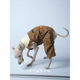 Dog wearing brown utility overalls over a cream shirt.