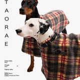 Close-up of plaid capes on a Dalmatian and a dark-coated dog.