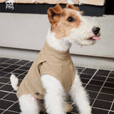 Terrier wearing a tan sleeveless high-neck top.