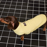 Side view of a yellow sleeveless top on a dachshund.