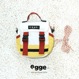 Yellow and white dog backpack with red buckle straps and matching cord.