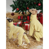 Dogs modeling yellow diamond-pattern bodysuits beside gifts.