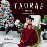 Dalmatian wearing a plaid hooded coat beside a woman and Christmas tree.
