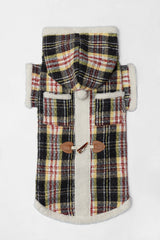 Plaid dog coat with a hood, pockets and toggle fastenings, laid flat.