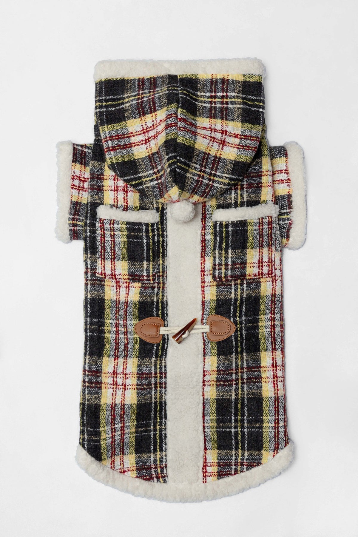 Plaid dog coat with a hood, pockets and toggle fastenings, laid flat.