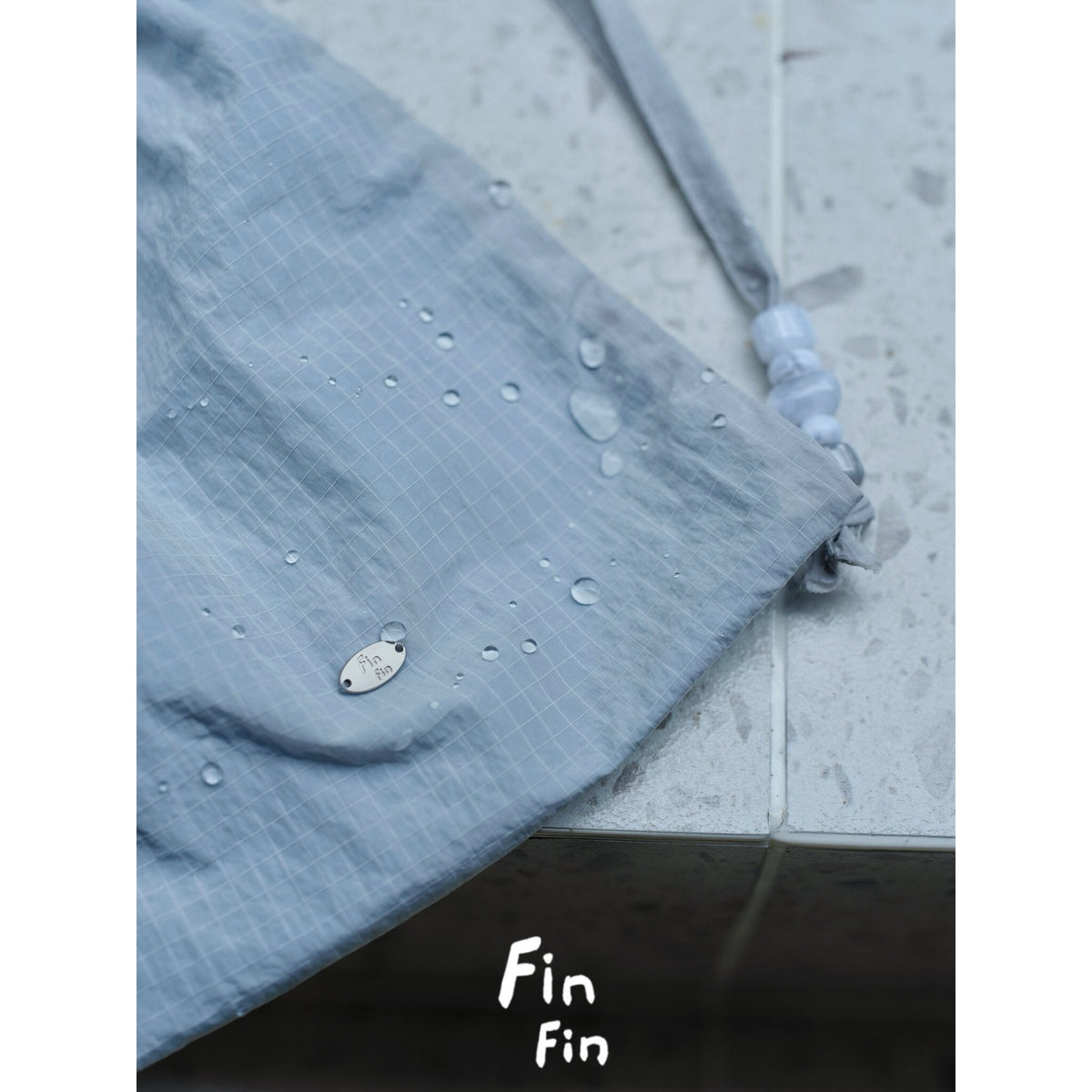 Close-up of gray dog outdoor suit fabric and snap fastening.