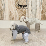 Two dogs modeling gray and olive padded bodysuits.