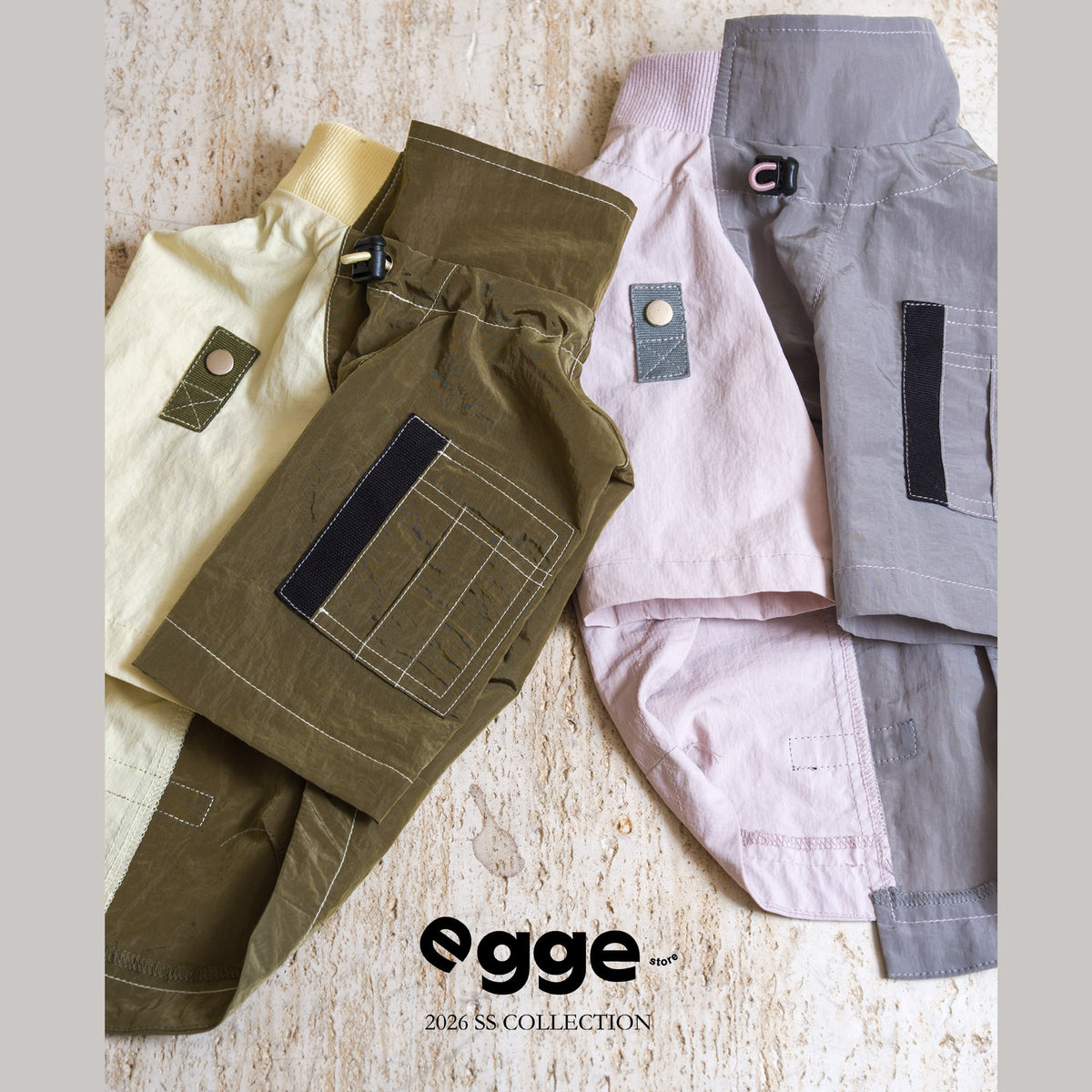 Olive, pink and blue dog sweatshirts laid flat with chest pockets visible.