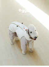 White dog wearing a cream padded bodysuit.