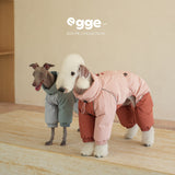 Two dogs wearing mint and pink colorblock puffer bodysuits.