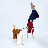 Dog standing upright in red jeans and a navy jacket.