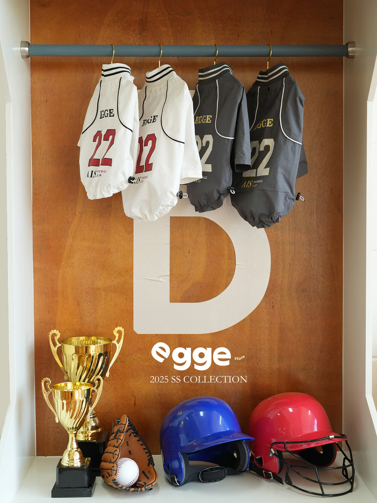 Egge basketball dog jerseys in white and charcoal hanging on a clothing rack.