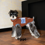 Side view of a rust dog vest with blue edging and a blue pocket.