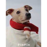 Close-up of a red dog scarf with cream-striped ends.