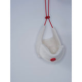 Cream dog aviator hat hanging from its red tie cords.