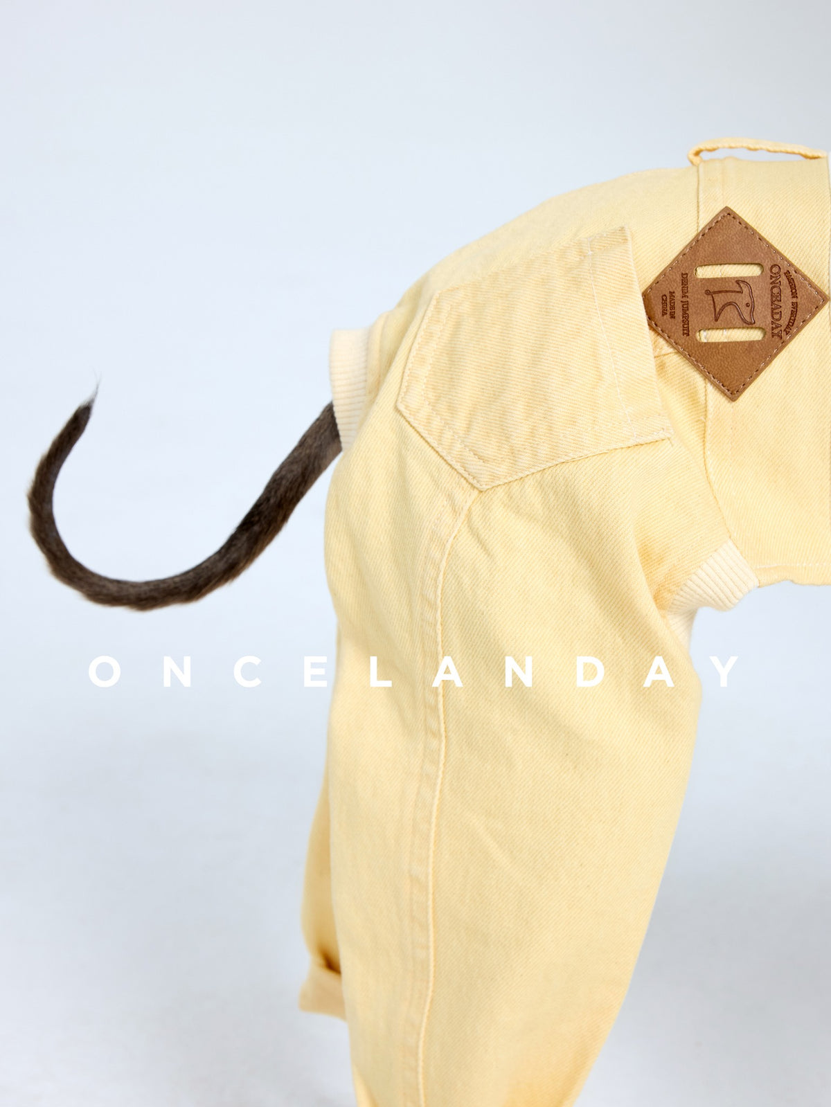 Close-up of yellow dog jeans with a waistband patch and tail opening.