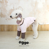 Side view of a dog wearing a pale pink varsity sweatshirt.