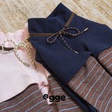 Navy and pale pink dog sweatshirts laid out to show plaid sleeves.