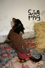 Rear view of a reversible dog vest with a brown back and red trim.