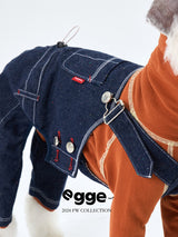 Close-up of washed denim dog overalls with buttons and adjustable straps.