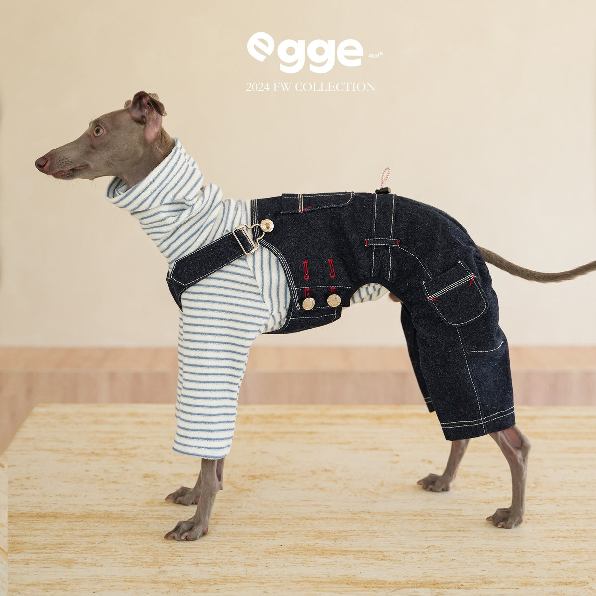 Side view of dark denim overalls worn over a striped dog shirt.
