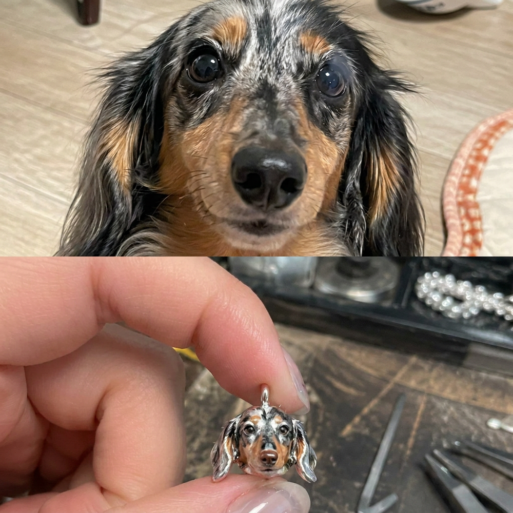 Long-haired Dachshund beside a custom handcrafted 925 sterling silver pet portrait charm.
