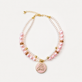 Pink and white pearl-effect pet necklace with gold-tone details and a pink Be Free pendant.