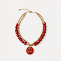 Red pearl-effect pet necklace with gold-tone beads and a red Be Free pendant on a white background.